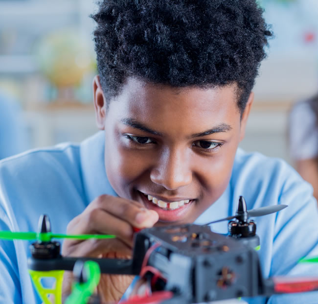 Child examining the robotics of a drone